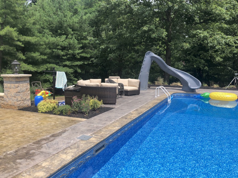 Cleveland Landscaping Company Project Backyard Pool with Seating Area behind Pillar & Plantings