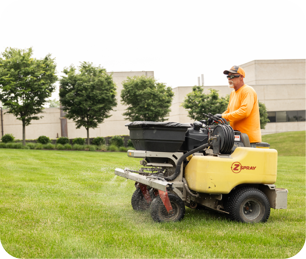 H&M Landscaping professional operating commercial-grade lawn care equipment for property maintenance, showcasing expert turf management services