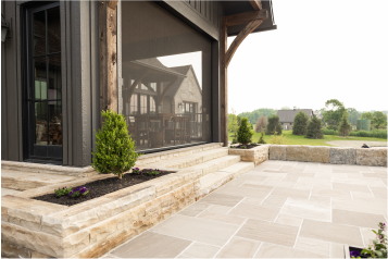 custom-patio-installation-ohio Newly installed stone patio with landscaping around a modern home